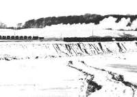 View north across fields from a lay-by on the A713 Ayr road to the west of Dalmellington in the aftermath of a snowstorm in December 1971 showing an NCB pug at Cutler Tip with a trainload of waste from the washery.<br><br>[John Furnevel 01/12/1971]