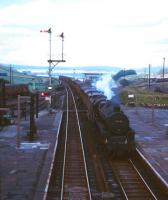 A southbound freight runs through Tebay behind Black 5 45041 in the early 1960s. The locomotive shedcode of 8C (Speke) is written on the smokebox door in chalk. The NER route over Stainmore Summit turns off to the east in the right background.<br><br>[Robin Barbour Collection (Courtesy Bruce McCartney) //]