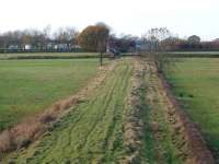 One of the few sections of the Garstang and Knott End Railway trackbed that can still be clearly seen is this stretch immediately to the west of the A6 main road. This view is towards Nateby Crossing Cottage [See image 18317] taken from the former bridge over the line, which closed to passengers in 1930 and completely in 1963. To the east of this point the trackbed is built over until it emerges on the other side of Garstang near the river. Map Ref SD 485457. [2016 update: This short stretch of G&KER trackbed, the crossing cottage and surrounding land have been earmarked for housing and may well disappear]. <br><br>[Mark Bartlett 15/11/2008]