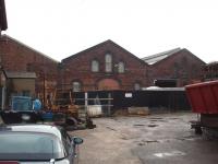 The centre section of the old Midland Shed at Carnforth still has the door by which the engines accessed the roundhouse, albeit bricked up. In 1920 there was an allocation of 61 locomotives here and it is still an imposing building, even though it is now in the middle of an industrial estate. View east with the Wennington line to the right of the building.  <br><br>[Mark Bartlett 20/11/2008]