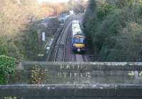 The 1530 Edinburgh - Glasgow shuttle runs through the remains of the former E&G Ratho station (closed 1951) on 24 November 2008. View east from the bypass showing the bridge that once carried Station Road through the village (this section is now a walkway/cycleway). Note the use of the old yard - formerly the site of the adjacent South Queensferry Branch Low Level station (closed 1930) - on the left, currently being used to accommodate equipment and materials  in connection with the nearby Newbridge Junction remodelling. [See image 21576]   <br><br>[John Furnevel 24/11/2008]