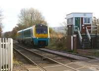 An <I>Arriva Trains Wales</I> service heads north on 18 November past the unusual design of SB at Onibury, Shropshire. The box controls the level crossing over the busy A49 road.<br>
<br><br>[John McIntyre 18/11/2008]