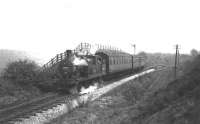 L&YR 2-4-2T 50651 climbs away from Woolfold station with its <I>last day</I> push pull train from Bury Bolton St, next stop Sunnywood Halt, on its way to Holcombe Brook. This print had no location details but there was only one passing loop on the branch, the points for which can just be made out behind the rear coach. The line in the foreground is the shunting neck for the goods yard. The raised signal indicates the signal box was switched out on this occasion. Print credited to N R Knight. [See image 21839] for a modern day 'Then and Now' comparison picture of the location. <br><br>[W A Camwell Collection (Courtesy Mark Bartlett) 04/05/1952]