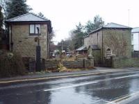 A view towards Stubbins, from the site of the level crossing at Helmshore, showing the now extended Station House, cutting and overbridge together with a cottage built on the site of, and in the style of, the old signalbox. In front of this one of the original level crossing gate posts can still be seen. The line to Accrington closed in December 1966 and the station site, behind the camera, has now been covered by housing.  <br><br>[Mark Bartlett 13/12/2008]