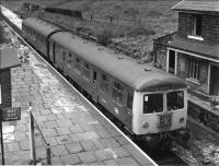 A Cravens DMU pulls into Ewood Bridge, one week before closure, on a Bury Bolton Street service with Alf Davenport in the driving seat. When the line between Bury and Rawtenstall was singled three signal boxes remained to control level crossings but the distant signals for these became fixed and Alf was not impressed. <I>If a man needs a fixed distant he shouldn't be on the railway</I> he would say. Fair point Alf - proud of his craft to the end, even on this very run down shadow of a former main line.<br><br>[W A Camwell Collection (Courtesy Mark Bartlett) 27/05/1972]