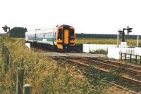 158 716 speeds north over Bow of Fife level crossing in July 2002.<br><br>[David Panton /07/2002]