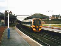 Aberdeen bound 158 707 at Arbroath on 17 July 1998. Shortly afterwards the canopies were cut back slightly and the station repainted which resulted in a much less gloomy atmosphere. <br><br>[David Panton 17/07/1998]