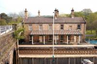 The imposing building on the eastbound platform at Corbridge. View north across the Newcastle & Carlisle line  in May 2006. The road on the left leads to the bridge over the River Tyne and what was the most northerly town in the Roman Empire, with the first fort established here in AD 85. The station building is now a restaurant.<br><br>[John Furnevel 08/05/2006]