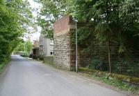 View south along the eastern exit road from the Peebles Hydro Hotel, just before it joins the A72. The single remaining bridge abutment marks the point at which the railway left the Hotel grounds and crossed the exit road on its journey from Peebles to Galashiels.<br>
<br><br>[John Furnevel 18/05/2008]