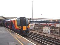 A Portsmouth Harbour service, with South West Trains 450021, calls at one of Clapham Junction's many platforms. In the background, in the V between these lines and those to Richmond, are the depot sidings. <br><br>[Mark Bartlett 16/01/2009]