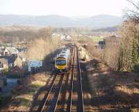 With the South Lakeland fells visible in the background, Transpennine Unit 185129 heads east after calling at Ulverston on its way from Barrow in Furness to Manchester Airport. The train will shortly cross the Levens Estuary viaduct before continuing round the coast of Morecambe Bay to Grange-over-Sands and beyond.<br><br>[Mark Bartlett 17/01/2009]