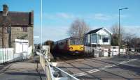 The Heysham Boat train has just picked up the ground frame keys at Bare Lane signal box so that it can access the Heysham Port Branch at Morecambe. The December timetable change with a through train from Leeds has seen class 144 DMUs, like 144002 here, at Heysham for the first time but this necessitated Barrow drivers being trained on this type of traction. 153332, in the other platform, is heading for Lancaster on a service from Morecambe.    <br><br>[Mark Bartlett 22/01/2009]