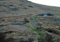 The Sannox Railway, Arran, was open from 1836-1862 and 1918-1939 to carry Barytes from mines to a pier. The earthworks remain relatively intact and portions of the pier remain. The upper works of the railway was a self-acting incline running from a reversing spur uphill to mines and associated bings. The lower works ran from the reversing spur via mines and various hoppers to a pier at Sannox north of Corrie. There were many mines here and on inspection the upper incline may have been rebuilt on at least three occaisions on different alignments. <b>There are many open shafts, partly demolished buildings and deep pools so caution should be exercised on visiting.</b><br><br>[Ewan Crawford 24/01/2009]