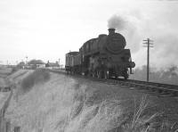 BR Standard class 4 2-6-0 no 76050 of Hawick shed photographed near Roxburgh Junction on 10 February 1964 with the lightly loaded Jedburgh freight. Although the branch lost its passenger service in 1948 it remained open for freight traffic until 1964 (although some sources quote 1966). Roxburgh station can be seen in the background, while the embankment on the right, from which the Jedburgh branch has just diverged, carried the <I>'main line'</I> towards Kelso and eventually on to the junction with the ECML just north of Tweedmouth station.<br>
<br><br>[Robin Barbour Collection (Courtesy Bruce McCartney) 10/02/1964]