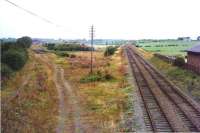 Site of the former Crosshouse station, Ayrshire, in August 1974, just over 8 years after closure. The route north west towards Dalry lies straight ahead, while the trackbed on the left once carried the line to Irvine.<br><br>[Colin Miller 11/08/1974]