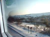 Snowy conditions in the valley to the east of Marsden station as 170306, on a Transpennine Manchester to Hull service, runs down towards Huddersfield. The Huddersfield Narrow Canal can be seen below the railway line. <br><br>[Mark Bartlett 03/02/2009]
