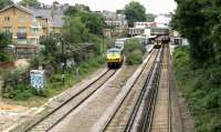 Looking east towards Highbury & Islington station NLL platforms in July 2005. A Richmond - North Woolwich <I>Silverlink</I> service stands at the eastbound platform, while a westbound freight runs past the station. The interchange links provided here, serving passengers on the North London Line, Victoria Line and Northern City Line will be further extended when the station becomes the new northern terminus of phase one of the East London Line extension in 2010. The London Borough of Islington is currently considering redevelopment of the station, including building a large office/retail block over the current station site.<br><br>[John Furnevel 22/07/2005]