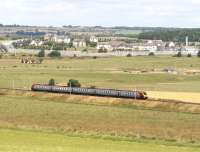 A Birmingham New Street - Edinburgh Waverley Voyager approaching Carstairs in July 2007. The train will avoid Carstairs station by taking the route via Carstairs South and East Junctions and will shortly cross the picture travelling in the opposite direction on the line in the background passing just in front of the security fence of the State Hospital.<br><br>[John Furnevel 31/07/2007]