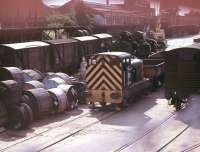 Originally known simply as 20, Ruston & Hornsby 4wDM 97020 was built in 1957 for use in Reading Signal Works and remained there all its working life. It was tricky to see as the yard was not visible from passing trains. By the time this photo was taken, through the bars of an overbridge, the shunter was on borrowed time as its replacement, Barclay Class 06 No. 06003, had arrived in Reading from Scotland [See image 22416]. 97020 never did leave this yard, being broken up there by a contractor in August 1982. The Signal Works closed later in the 1980s.<br><br>[Mark Bartlett 18/07/1981]