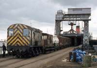 Before the Channel Tunnel was opened, Harwich Town station saw considerable train ferry activity, as seen here in April 1978 with 08 460 (the regular engine) drawing out the traffic from Zeebrugge. Usually, loading and unloading was timed with the tide to ensure the ship to shore ramp was horizontal, but in later years staff became more prepared to attempt the job with the ramp set at a very steep angle. Perhaps by trial and error, they discovered that Class 08 locos are quite capable of hauling heavy loads up 30 degree slopes!<br><br>[Mark Dufton 15/04/1978]