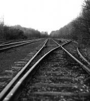 View over Faslane Exchange Sidings, photographed around 1978.This was a fascinating place - like something out of <I>Casey Jones</I>. It was laid during WW2 as Military Port No 1 Railway using wartime continental standards (light flat bottom rail spiked through baseplates onto the sleepers, staggered joints, right-hand running, etc). The yard had 7 lines at one time I believe, although latterly only one track was used for traffic to and from <I>Shipbreaking Industries Ltd</I>. The line was felt to pose a potential security threat as it ran through the Faslane Base and its last chance of survival went when the option to use it during the rebuilding of Faslane for <I>Vanguard</I> was rejected in the 1980s.<br>
<br><br>[Johnny Trippick //1978]