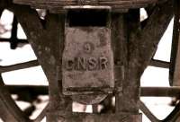 A GNSR axlebox cover - part of a set that remained at the Longmorn distillery after BR closed the line from Elgin in the 1960s. The Distillery retained a rail system to transport materials around the site until late 1979, when the track, locomotives and wagons were gifted to the Strathspey Railway. <br>
<br><br>[Peter Todd //1979]
