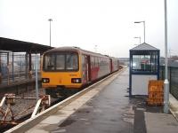 The roof and side panels were drastically cut back at Heysham Port station shortly before this picture was taken, making it an ever bleaker spot than before. 144004 waits to depart for Leeds with the daily service, a journey that involves reversals at Morecambe and Lancaster before taking the Carnforth to Skipton line.<br><br>[Mark Bartlett 14/02/2009]