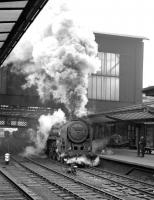 Kingmoor Britannia 70013 <I>Oliver Cromwell</I> makes an aggressive start from Carlisle platform 3 with a northbound train in February 1965.<br><br>[Robin Barbour Collection (Courtesy Bruce McCartney) 13/02/1965]