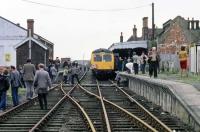 A passenger train to Dereham was still a rare event in 1980 and this special, organized by the Fakenham and Dereham Railway Society, was well patronized by local trippers as well as enthusiasts. Notable from today's viewpoint is the complete lack of safety concern, with adults and toddlers alike scrambling freely over track and platforms. Needless to say, no one was harmed during the taking of this photo. The train was headed to Great Ryburgh - the end of the line following the closure of the section beyond to Fakenham a couple of months earlier.<br><br>[Mark Dufton 11/10/1980]