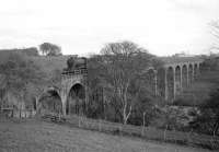 Thornton J38 no 65915 coming off the viaduct into Leslie with 6 mineral wagons in 1966. Although the station lost its passenger service as long ago as 1932, the branch remained open for freight traffic until 1967. Developments on the western edge of Glenrothes New Town can be seen in the background.<br><br>[Robin Barbour Collection (Courtesy Bruce McCartney) //1966]