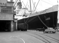 A boat train special stands alongside the RMS <i>Queen Mary</i> at Southampton Docks in 1963. The liner, built by John Brown & Co, Clydebank, and launched in 1934, was retired from service on the North Atlantic run in 1967 and is now permanently berthed in Long Beach, California, serving as a museum ship and hotel. <br><br>[Robin Barbour Collection (Courtesy Bruce McCartney) 17/07/1963]