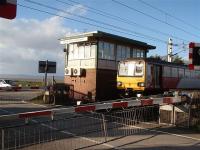 The wind gauge on Hest Bank signal box was spinning furiously on a very blustery day as 144012 passed on a Morecambe to Leeds service. The gauge was installed when this exposed stretch of line was electrified. If wind speeds rise above a certain level the trains run slowly at caution to protect the overhead catenary. Behind the box the foreshore can be seen, the sands of Morecambe Bay at low tide and, in the distance, the Cumbrian coast near Kents Bank.  <br><br>[Mark Bartlett 23/03/2009]