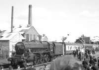 The LCGB <I>Lancastrian</I> railtour from Liverpool Lime Street, hauled by 45305 calls at Burscough Bridge on 6 April 1968 on its way to Southport. The junction signals above the third coach cover the north curve (left) towards Rufford & Preston, the line to Wigan (straight on) and the South Curve (right) towards Burscough Junction and Ormskirk. The chimneys and factory behind the locomotive have now gone. Behind the junction signal is the A59 road overbridge, from which the steps down to the eastbound (Wigan) platform are just visible.<br><br>[K A Gray 06/04/1968]