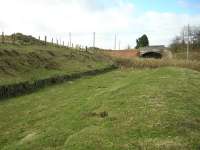 What may appear at first glance to be wooden platform remains east of Greenlaw station, seen here in March 2009, is in fact part of the stabilising wall for the embankment. Part of the main station building, now a private residence, can be seen just beyond and to the right of the bridge in the background.<br><br>[Ian Whittaker 13/03/2009]