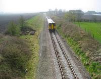 153332 leads an Ormskirk - Preston service between Burscough Junction and Rufford on 3 April 2009. This former double track main line from Liverpool Exchange to the WCML at Farington Curve Junction now normally operates using a one train shuttle following severance at Ormskirk in the 1970s. On the left of the tracks is the base for the tank that supplied the former Rufford water troughs here during steam days.<br>
<br><br>[John McIntyre 03/04/2009]