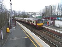 320 303 pulls away from Dalreoch with a Balloch service on 1 April 2009, while electricians install new platform cameras and monitors.<br><br>[David Panton 01/04/2009]