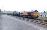 EWS 66050 descends from Chalmerston passing the Ayrshire Railway Preservation Group's Dunaskin platform with coal hoppers in May 2001.<br><br>[Colin Miller 12/05/2001]