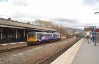 A fine row of traditional buildings survive on the Huddersfield platform at Stalybridge, including the famous station buffet, but at street level there is also a brand new travel centre. Pacer 142007 calls on a Northern, all stations, service from Manchester to Wakefield.<br><br>[Mark Bartlett 04/04/2009]