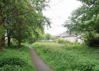 Caton station closed in 1960, six years before the line itself, and this picture is of the site, looking towards Hornby. The extended station house can be seen although the platforms have been removed. The goods shed (now a church - see picture 20472) is just beyond the former level crossing where a stone wall has now been built across the trackbed. The cycle path skirts the trees on the left at this point before rejoining the old line towards Claughton.<br><br>[Mark Bartlett 10/05/2009]