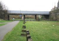 A Sunday morning jogger takes the former Caledonian route heading east towards Leith Docks on 15 March 2009 and is just about to pass below Lindsay Road bridge. The 6 lines once spanned by the bridge ran to the Western Docks, Leith North Goods Depot and Leith North passenger station, while off to the right at street level beyond the wall stood the large George Street mineral depot.    <br>
<br><br>[John Furnevel 15/03/2009]