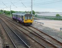 Only two passenger trains a day traverse the Bare Lane to Hest Bank chord - the 0551 and the 1620 from Morecambe.  No contest then for which one to photograph!  142050 rejoins the mainline at Hest Bank on its way to Leeds via Skipton.  Hest Bank station's down platform used to occupy this area but after closure in 1969 the platforms were removed and the chord extended to near the level crossing.<br><br>[Mark Bartlett 13/05/2009]