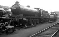 The works yard at Darlington in late 1963, with newly built Type 2 diesels D5231 and D5232 in the left background. A product of the same works 44 years previously, is Raven Q7 0-8-0 no 63460, the most powerful freight locomotive built by the NER (as class T3 in 1919), withdrawn by BR at the end of 1962 and destined for preservation as part of the National Collection. Railscot note: All 15 Q7s ended their operational days at Tyne Dock shed, being utilised primarily to haul iron ore trains from the coast up to Consett Iron Works on the western edge of County Durham. On steeper sections of the line a second Q7 was used as a banker. The locomotives were eventually displaced in the late 1950s by the arrival at Tyne Dock of new BR Standard class 9F 2-10-0s. No 63460 is currently on display inside North Road Museum [see image 18893].<br><br>[K A Gray 26/10/1963]