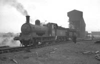 J25 no 65645 shunts a high-capacity iron ore hopper alongside the loading gantry at Tyne Dock bottom in March 1960. The 40 plus locomotives allocated to Tyne Dock shed around that time included 10 of the powerful Standard class 9F 2-10-0s, all fitted with Westinghouse air compressors for operating the discharge doors on these hoppers during unloading at Consett.  <br>
<br><br>[K A Gray 26/03/1960]