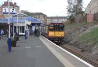 314 203 stands at a smart-looking Queens Park with a Cathcart Outer Circle train on 2 May 2009.<br><br>[David Panton 02/05/2009]