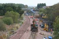 Looking east toward Bangour Jct in October 2007. The Bangour railway left the E&B near where the rooftops are visible centre left.  A temporary loop has been installed to allow ballast trains past the newly slewed up/down single line. Just beyond where the on-track plant is located was the end of a siding known as <i>Dechmont</i> - worked by up trains only.<br><br>[James Young 12/10/2007]