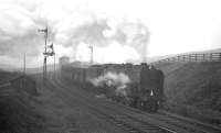 Not the ideal time for quiet contemplation amongst the good people of Annfield Plain, as a pair of Tyne Dock's finest wrestles 700 tons of iron ore onwards and upwards past Annfield East box on the final leg of the climb towards Consett steel works in February 1964. 92066 is the train locomotive on this occasion with 92063 banking.<br><br>[K A Gray 15/02/1964]