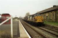 37354 and 37214 head a cement train through Clitheroe south-west towards Blackburn in March 1992. At this time passenger services to Clitheroe from Manchester had not restarted, however a considerable amount of work has been carried out to the platforms, including the provision of new shelters. The original station building on the right was not part of the reopening plans however it has since been restored and now is used as a gallery. The train had originated from Horrocksford cement works, a short distance to the north-east. One of the works chimneys can be seen in the distance above the platform. <br><br>[John McIntyre 31/03/1992]