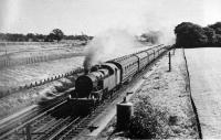 Just north of Brock station a Fowler 2-6-4T hurries 7 coaches over Brock water troughs and on towards Lancaster. A grainy, undated photo but the earthworks behind are from the construction of the M6 Motorway and so this is the early 1960s.<br><br>[Rev Ron Greenall Collection //]