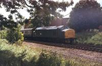 37228 heads for Blackpool North with a passenger train and has just passed under the Blackpool Road bridge in Ashton, Preston. This view, taken from Haslam Park, is no longer possible as the Preston Ring Road <I>Tom Benson Way</I> has been built alongside the railway on the land in the foreground, formerly occupied by the fast lines, and a high fence installed. 37228 subsequently became 37696 and, after a long period stored at Long Marston, was scrapped by CF Booths in Rotherham in 2014. <br><br>[Mark Bartlett 02/07/1983]