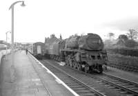 Ex-Crosti boilered 9F 2-10-0  no 92024 coasts through Beattock station with a southbound freight in the sixties, having just descended the bank. Meantime, an exchange is taking place with the guard of a passenger train standing at the northbound platform, possibly concerning the whereabouts of the banking locomotive.<br><br>[Robin Barbour collection (Courtesy Bruce McCartney) //]